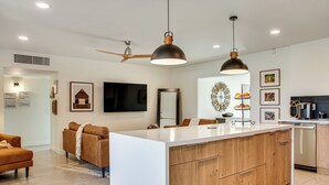 A modern kitchen with a central island, wooden cabinets, and pendant lighting. - Fun w/ Friends! Old Town Escape w/ Outdoor Oasis (Scottsdale)