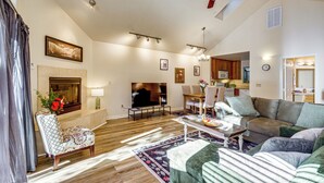 A spacious living room with a fireplace, a ceiling fan, and a dining area. - Redwoods Escape w/ Hot Tub: Near Russian River! (Guerneville)