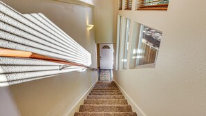 A carpeted staircase with a handrail, a door at the bottom, and a window with blinds. - Redwoods Escape w/ Hot Tub: Near Russian River! (Guerneville)