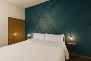 A bedroom with a bed, two bedside tables with lamps, a wardrobe, and a teal accent wall. - Soulard River-View Loft - 2 King BR - Parking (St. Louis)