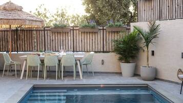 Een buitenzwembad, ligstoelen bij het zwembad