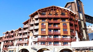 A multi-story hotel with balconies and a ski lift in the background. - Apartment in Savoy Near ski Slopes (Les Belleville)