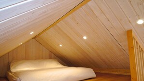 A single bed in a sloped ceiling room with wooden walls and a wooden floor. - Holiday Homes With Swimming Pool, Close to the sea (Międzyzdroje)