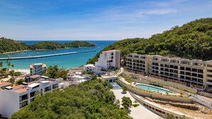 Ein Küstenhotel mit Pool, mehreren Gebäuden und einer an die See reichende Anlegestelle.