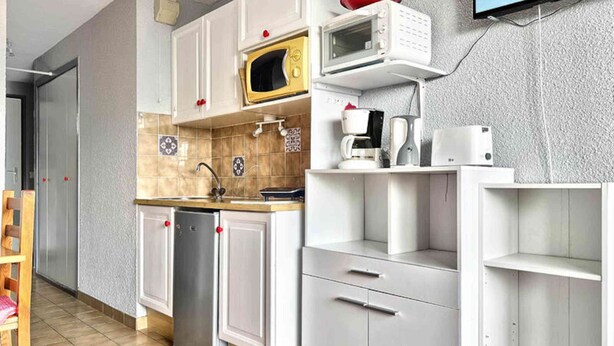 A compact kitchen with white cabinets, a microwave, a coffee maker, and a dishwasher. - Apartment in Servages With Ski-in Access (Araches-la-Frasse)
