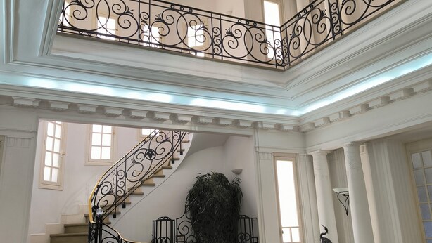 A grand interior with a staircase, white walls, and a white sofa. - Chambre d'hôtes in Demeure Remarquable / independent entrance (Béziers)
