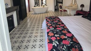 A hotel room with a bed, a vanity with a mirror, a bathtub, and a ceiling light fixture. - Chambre d'hôtes in Demeure Remarquable / independent entrance (Béziers)