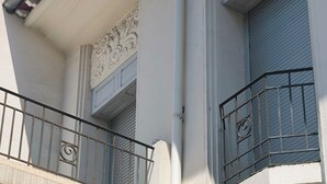 A building with ornate architectural details, including decorative moldings and a balcony with a metal railing. - Chambre d'hôtes in Demeure Remarquable / independent entrance (Béziers)