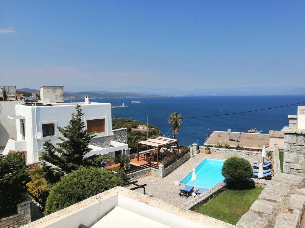 A residential property with a swimming pool, a patio area, and a view of the sea.