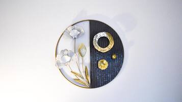 A circular wall decoration with a split design, featuring a floral arrangement and a ring on one side.
