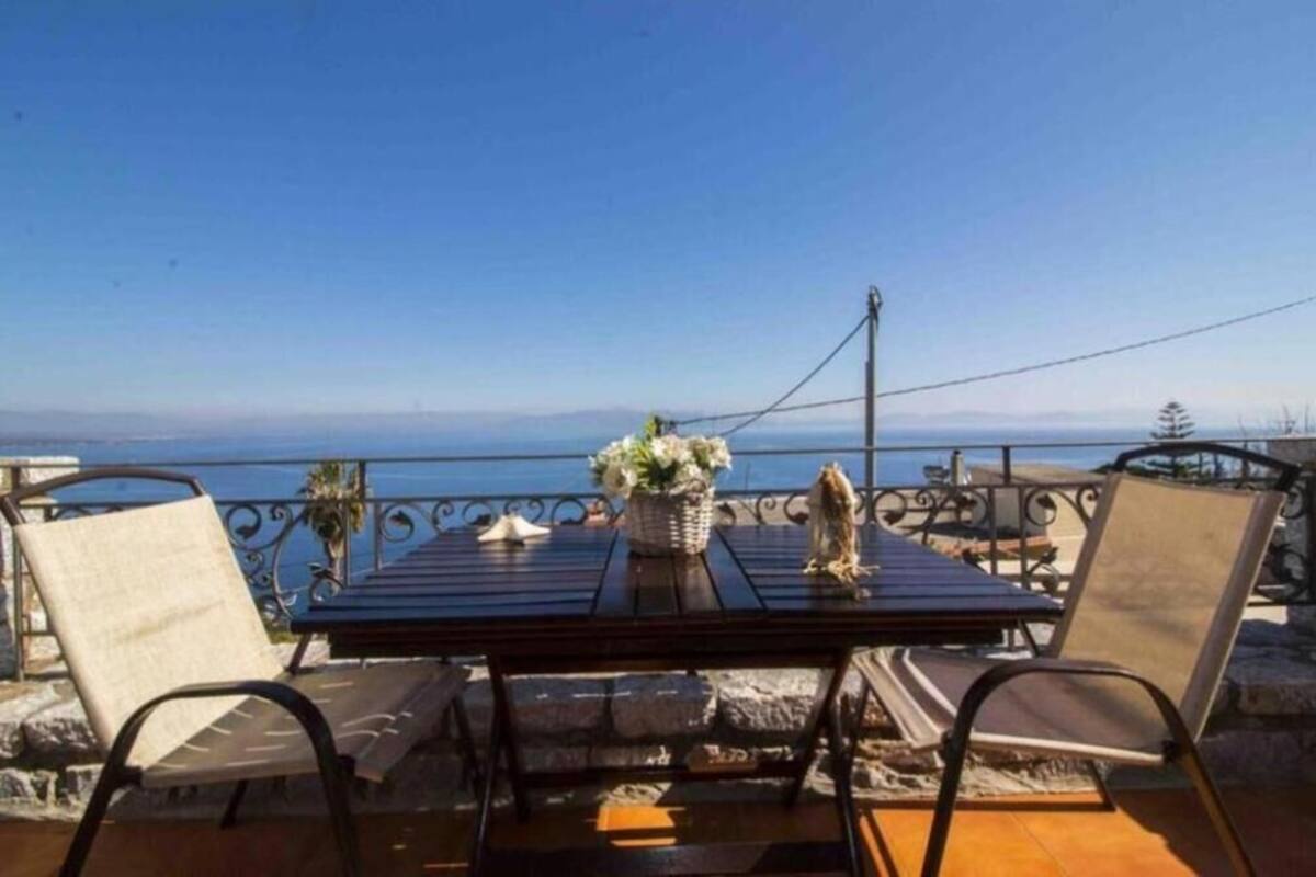 Une terrasse avec une table et des chaises, offrant une vue sur la côte.