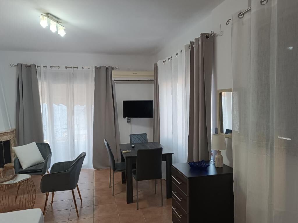 Una sala de estar moderna con chimenea, comedor y televisor.