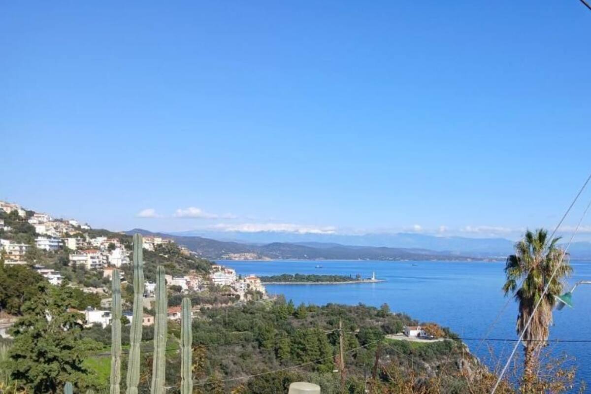 Un paysage côtier avec des bâtiments, un phare et un ciel bleu dégagé.