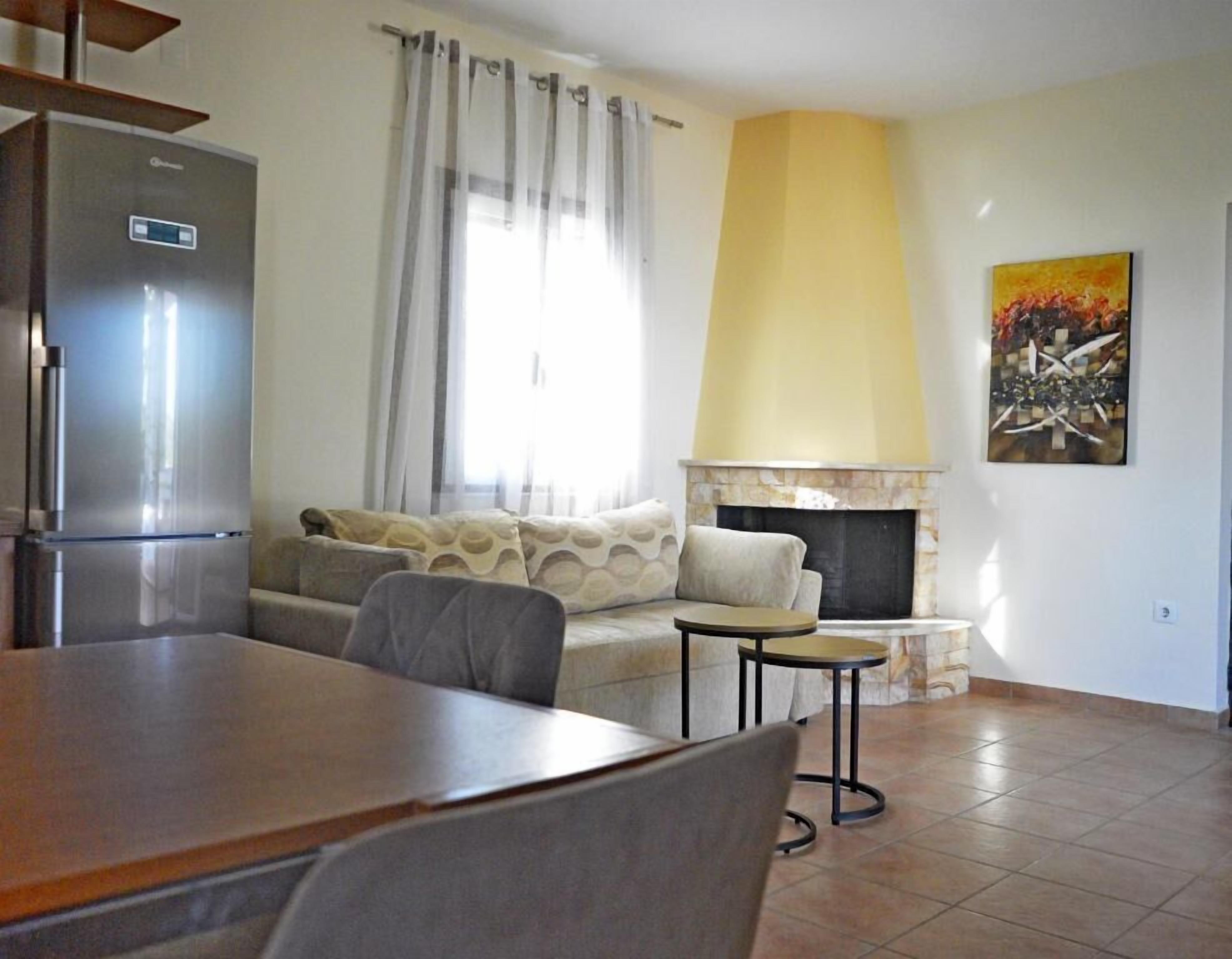 Ein Wohnzimmer mit Sofa, kleinem Tisch, Kamin und Kühlschrank.