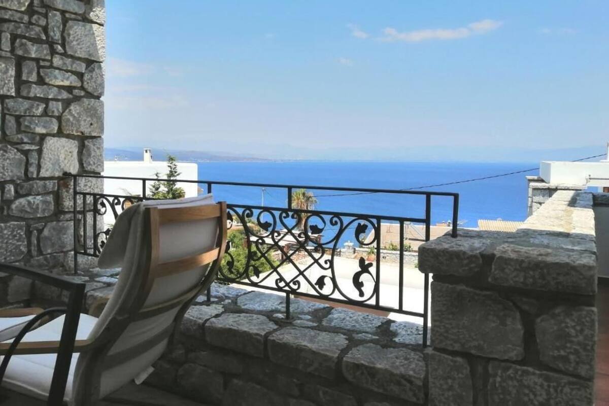 Un balcon en pierre avec une balustrade en métal, offrant une vue sur la côte.