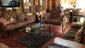 A cozy living room with a TV, comfortable sofas, a coffee table, and a dining area with chairs and a table. - 🎥✨ Imagine waking up to the sound of the sea, a cup of coffee on the terrace. (Puerto Vallarta)