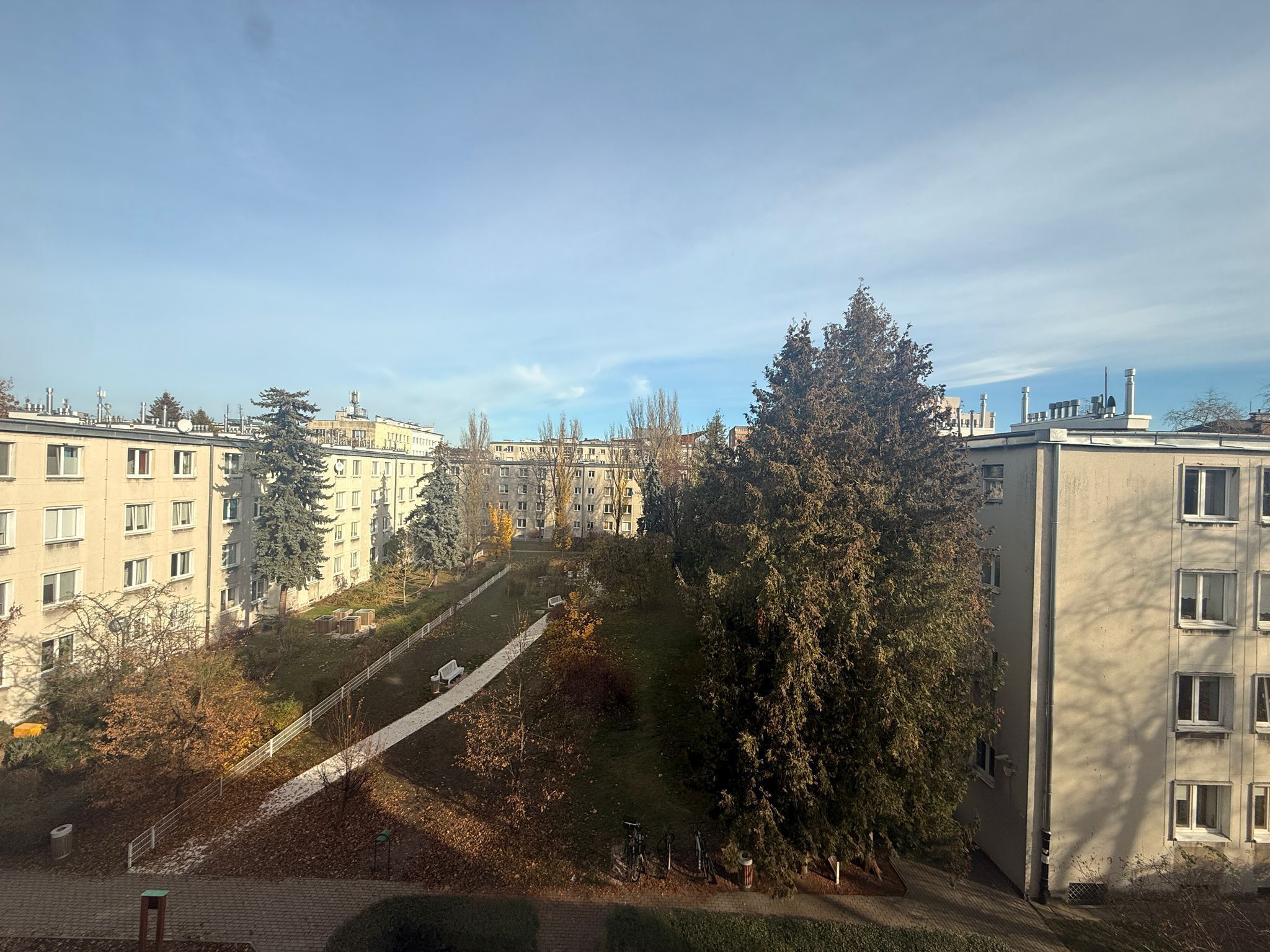 Une cour intérieure avec un chemin central, entourée d’immeubles à plusieurs étages dont l’architecture est uniforme.