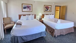 A hotel room with two beds, a chair, a desk with a lamp, and two framed pictures on the wall. - Grand Lodge Crested Butte #425 | Walk to Lifts | Sleeps 6, Hot Tub (Crested Butte)