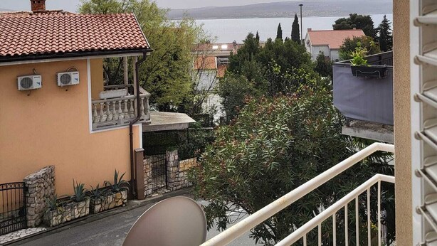 A balcony with a view of a body of water and buildings in the distance. - Seaside Apartment Bubi (Crikvenica)