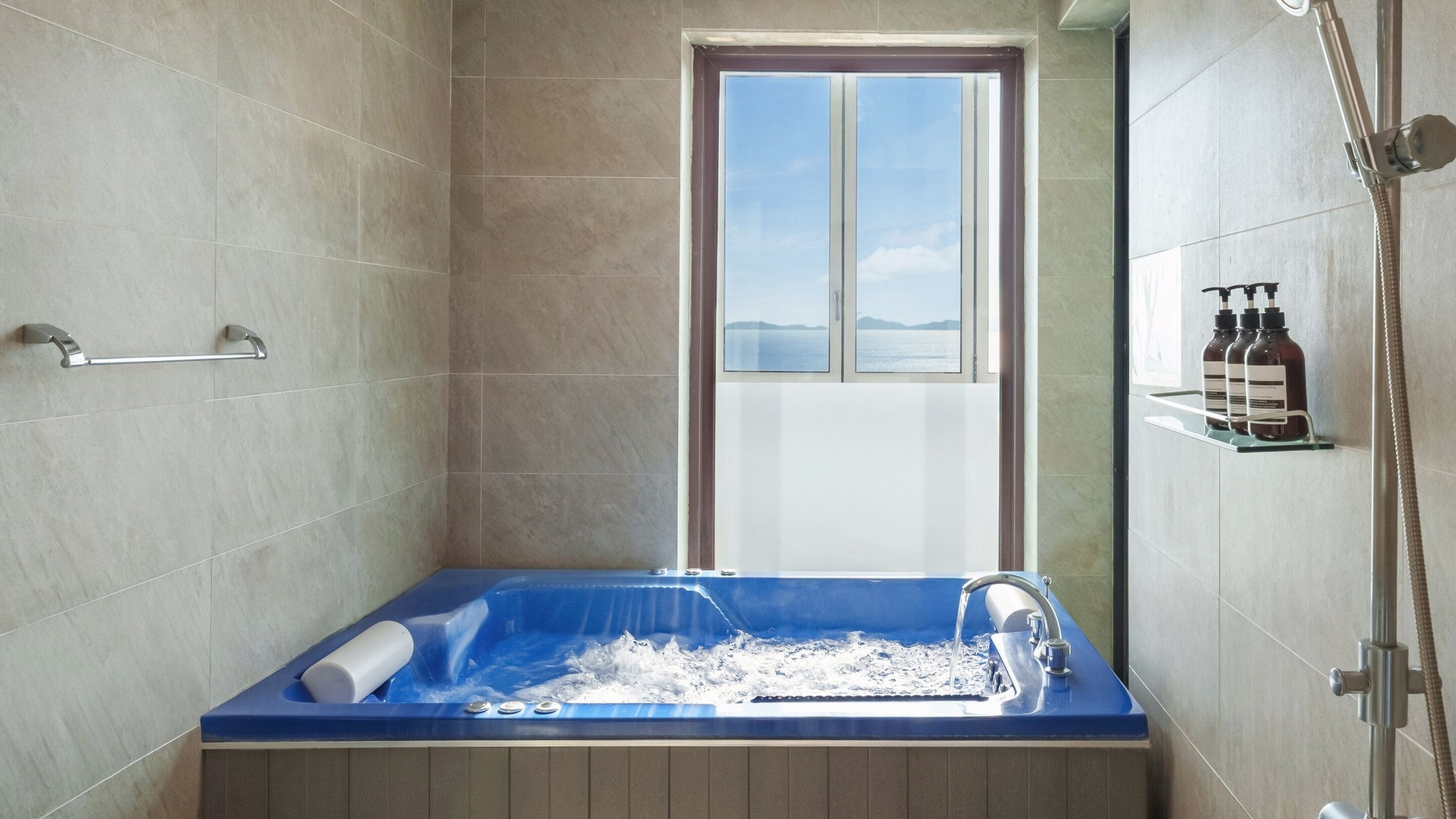 A bathroom with a bathtub, a window, and a shower.