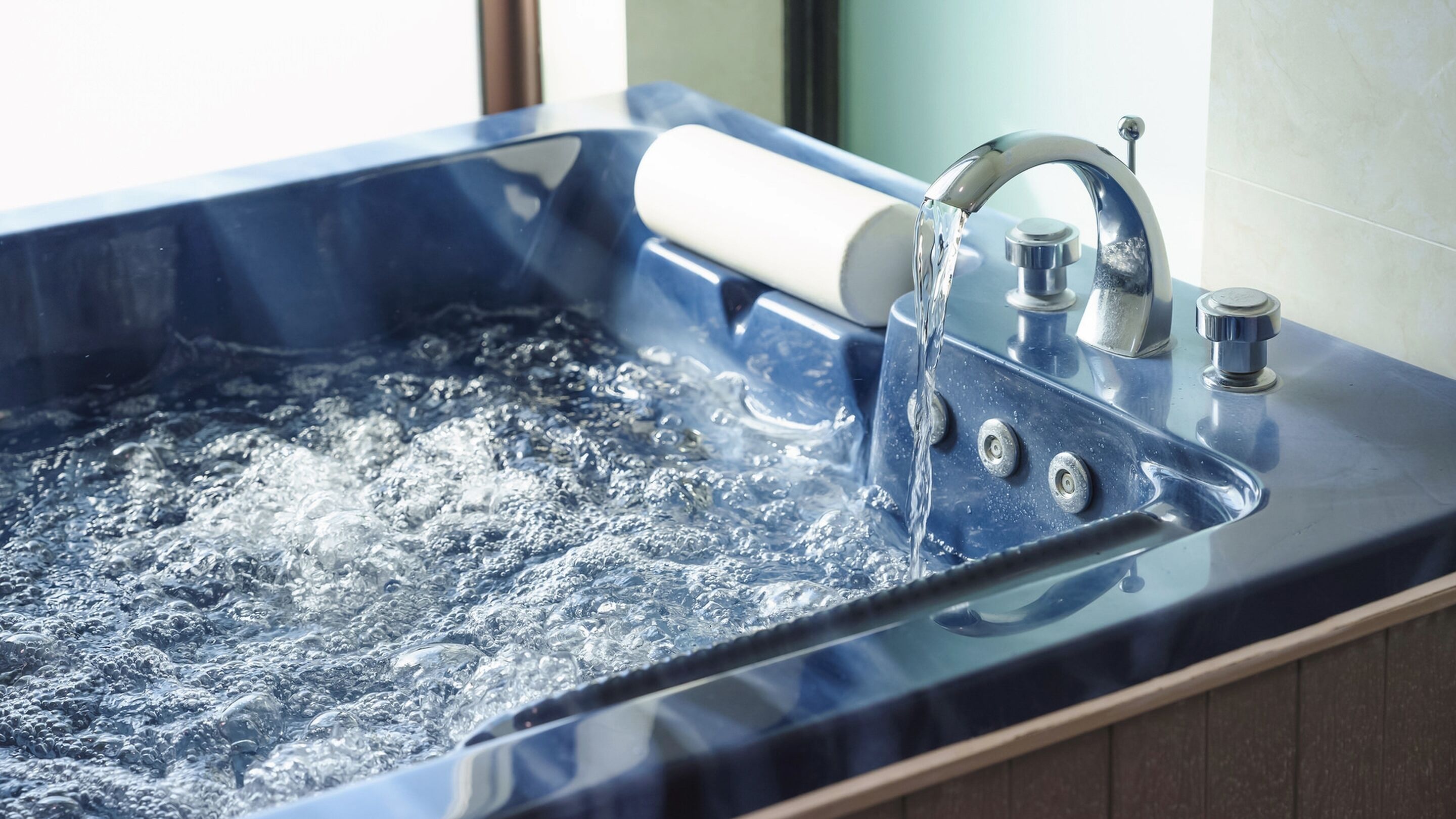 Un bagno moderno con una vasca da bagno ampia, un rubinetto cromato e un bocchello dell'acqua a vista.