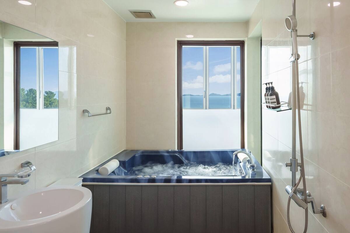 Une salle de bain moderne avec une grande baignoire, une douche et un lavabo.