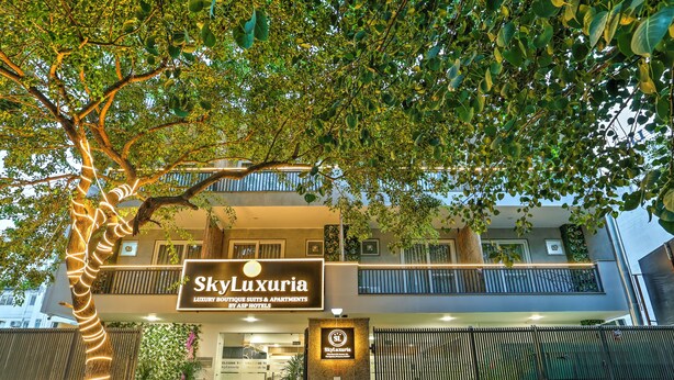 Un edificio con un cartel que dice "SkyLuxuria Luxury Boutique Suites & Apartments by ASP Hotels".