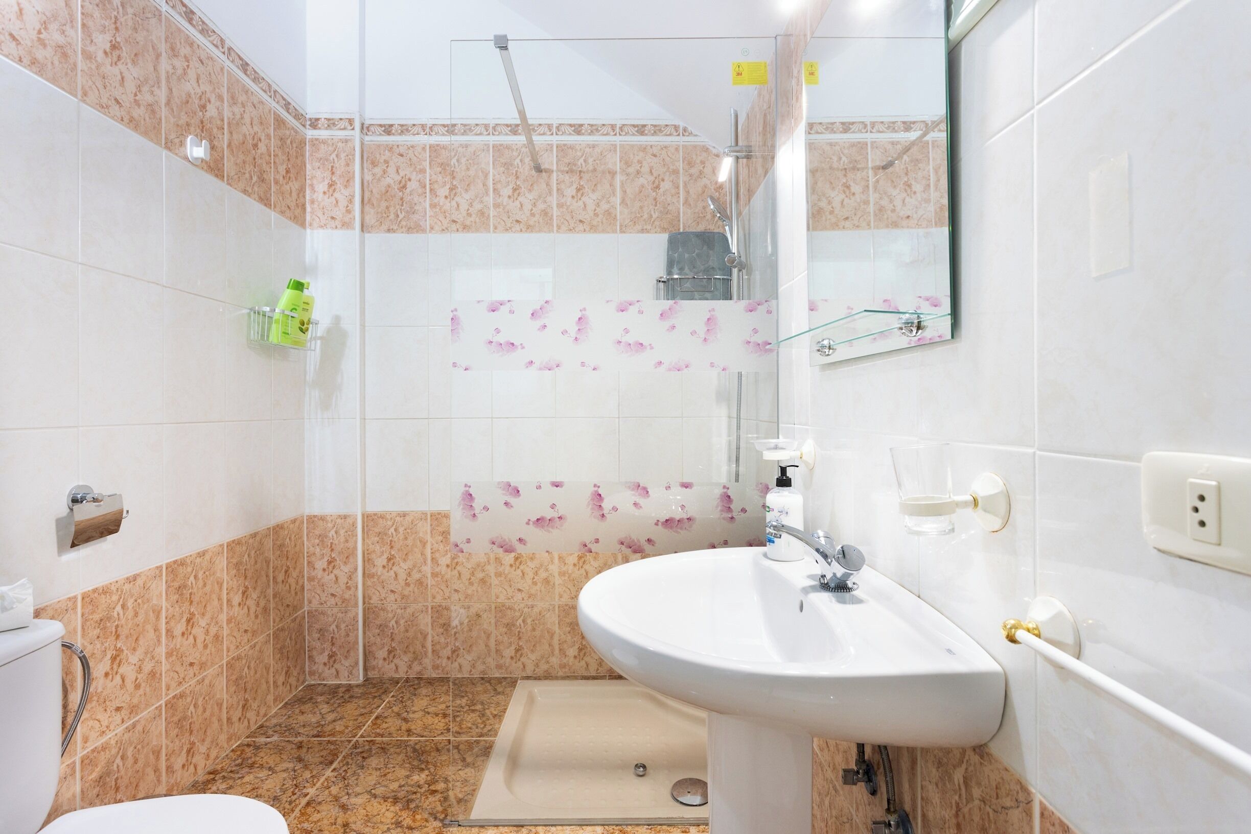 Ein Badezimmer mit Dusche, Waschbecken und Toilette.