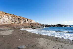 Una spiaggia con scogliere rocciose e onde.