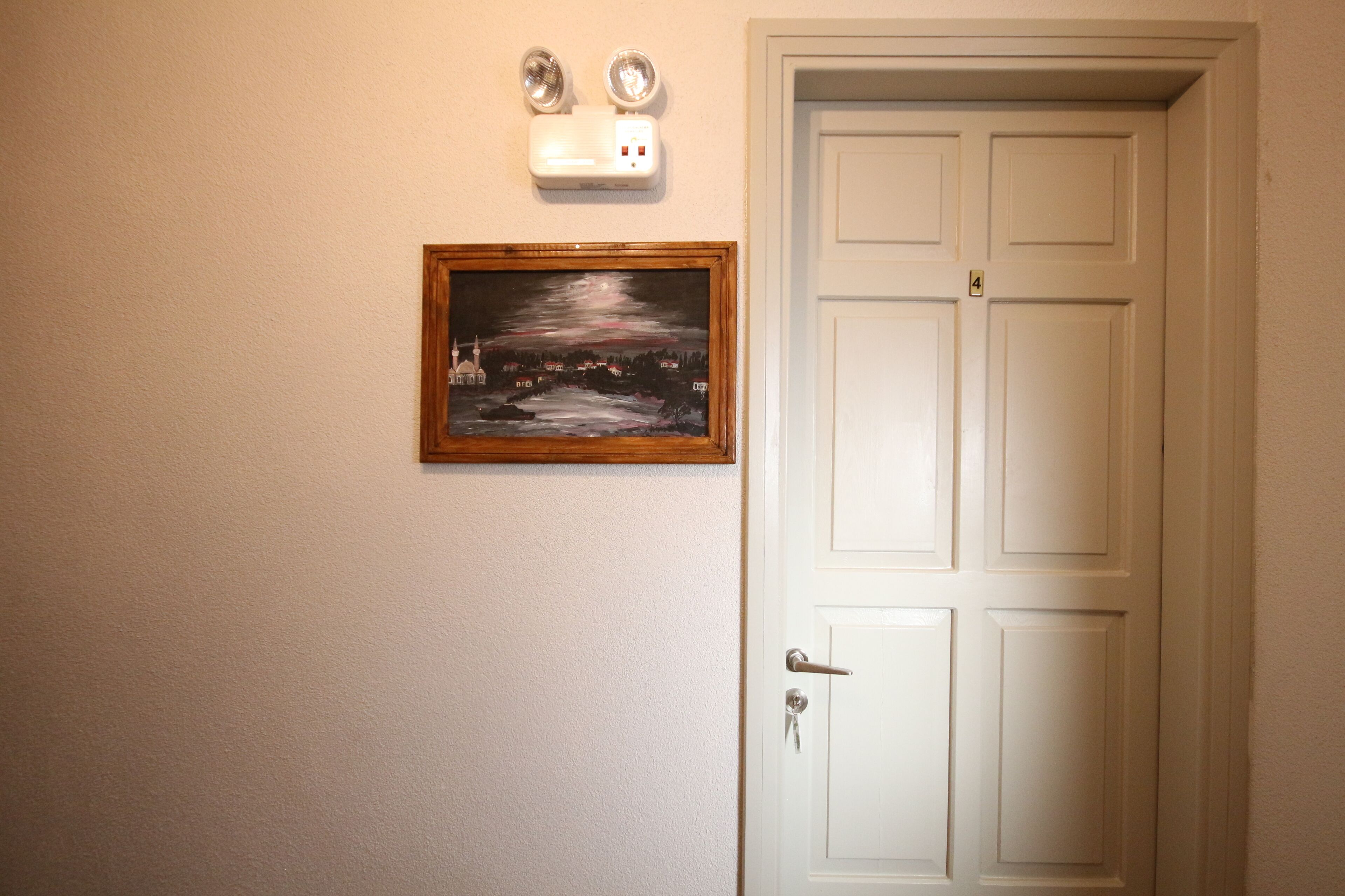 A white door with a keyhole and a doorbell.