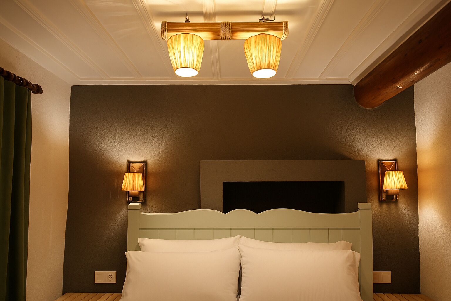 A hotel room with a bed, two wall-mounted lamps, and a ceiling light fixture.