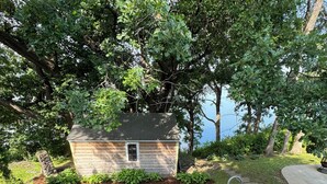 A wooden deck leading to a small house with a view of a lake.