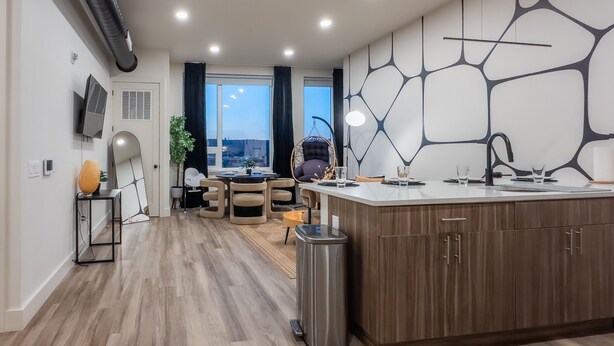 Une cuisine moderne dotée d’un îlot central, de meubles en bois et d’un évier encastré.