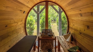 A cozy wooden cabin with a circular skylight, a grill, and a bench. - Tower on the Tuck: Entire home on the Tuckaseegee River near WCU -Riverfront (Cullowhee)