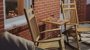 A brick exterior wall with two windows, a wooden bench, and a table with chairs. - Reconnect with Nature Farmhouse sleeps 6, two large bathrooms, full kitchen, (Whiteville)