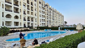 Un hôtel doté d’une piscine, de plusieurs balcons et d’un jardin bien entretenu.