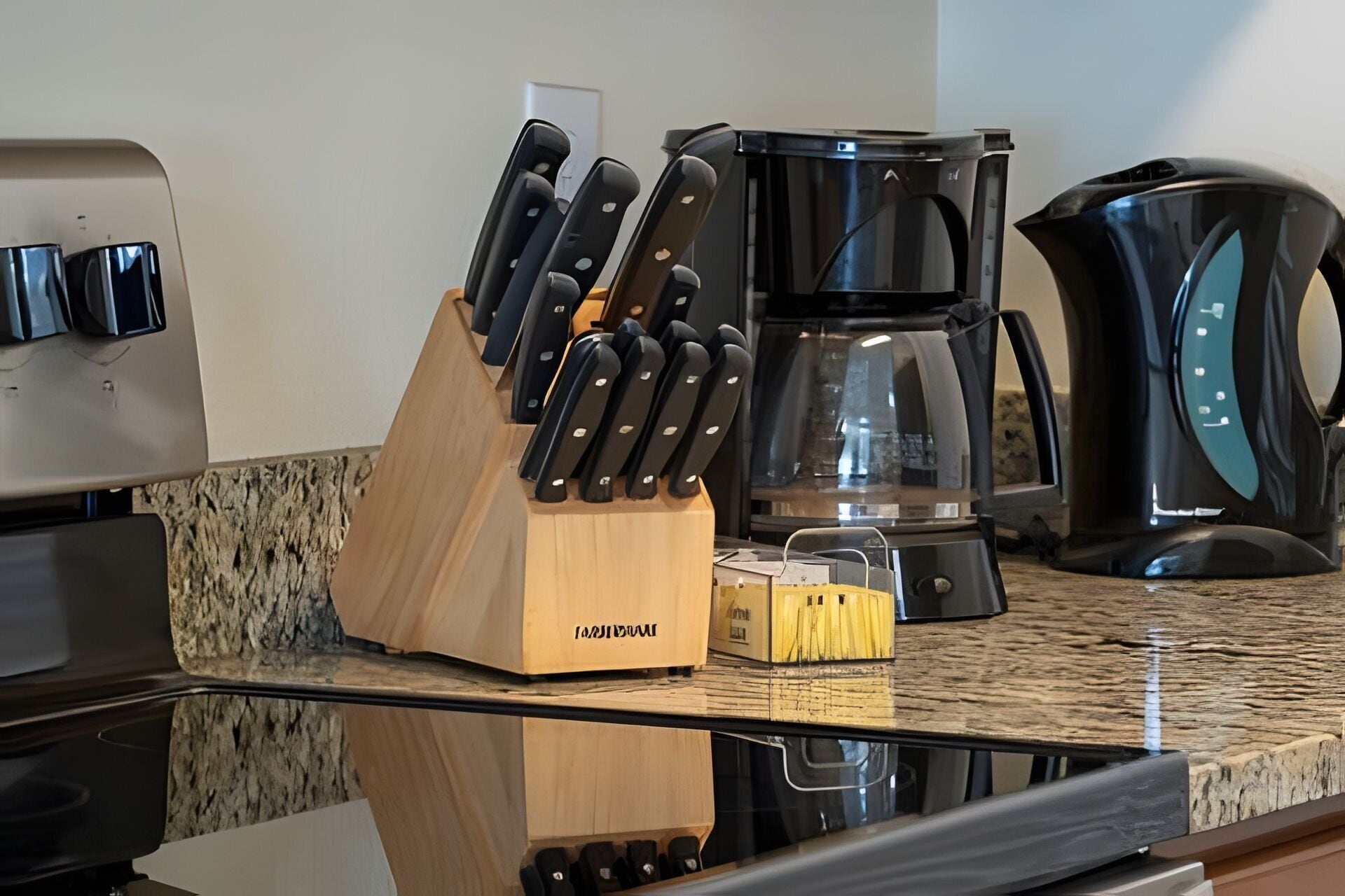 A kitchen counter with a knife block, a coffee maker, and a toaster.
