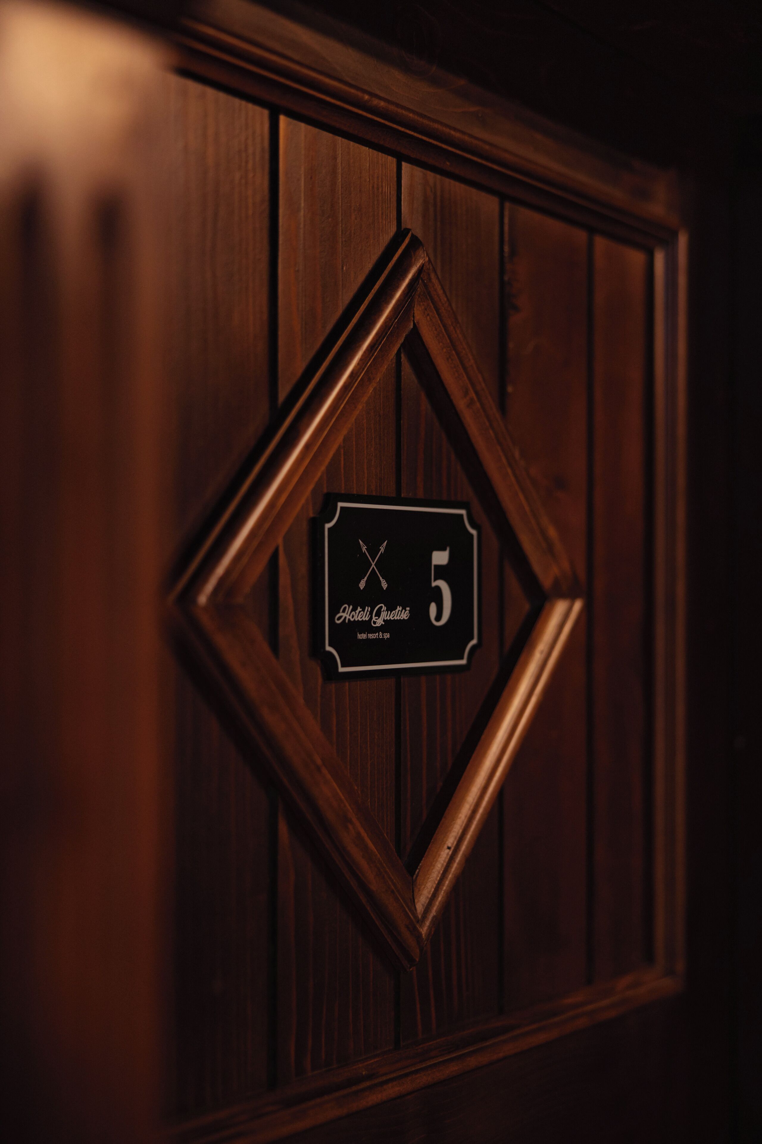 En træpanel med et skilt, der angiver værelsesnummer 5 på Hotel Quedlinburg.