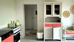 A compact kitchen with a stove, cabinets, and a small dining area with a table and chairs.