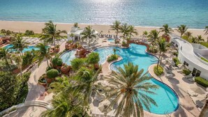 A resort with multiple swimming pools surrounded by palm trees and a beach view. - ★Miami Spacious Retreat 10 ninutes to Ocean • BBQ Pool Firepit• Sleeps 20+★ (North Miami Beach)