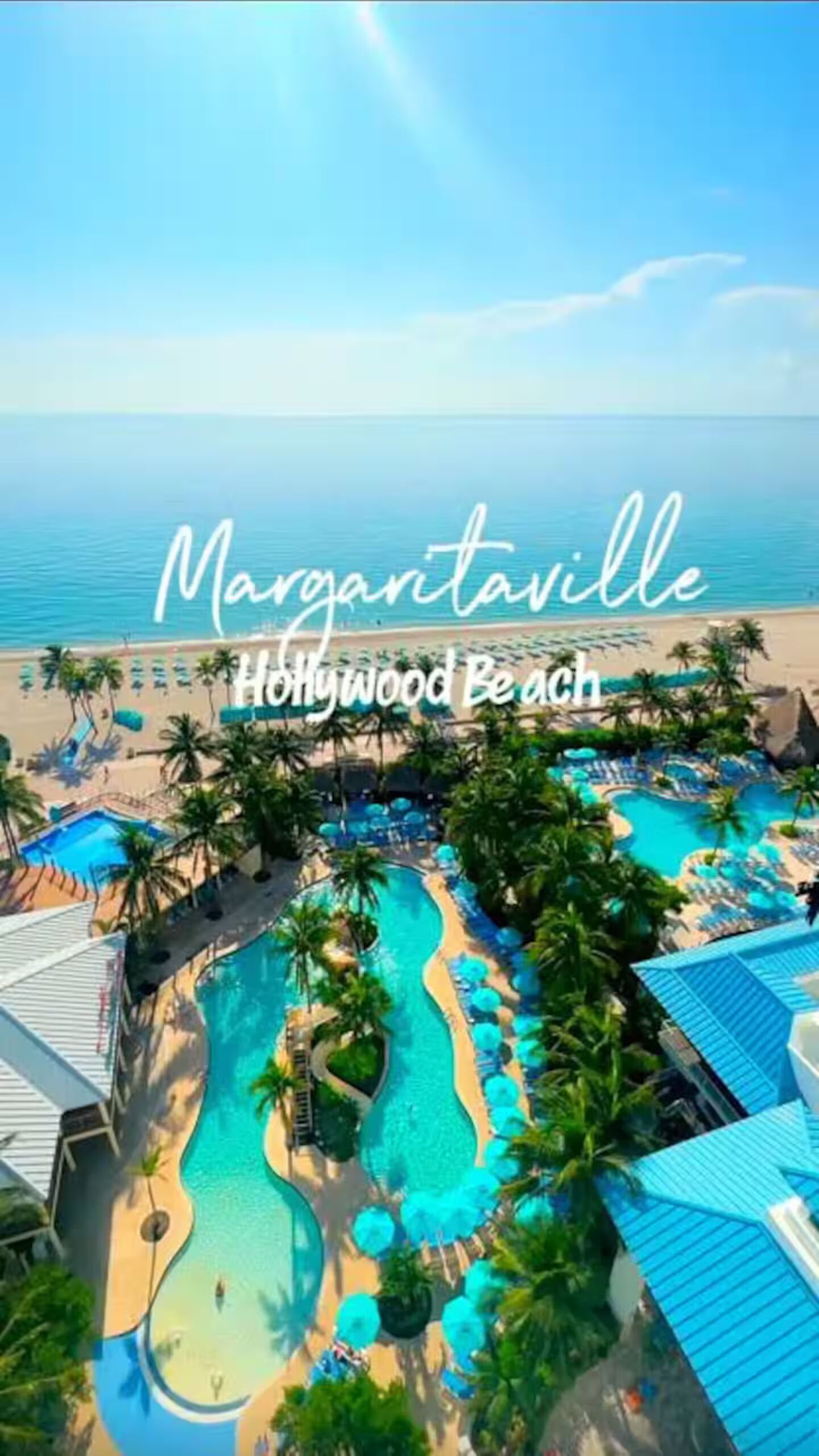 Ein Resort mit Poolbereich, Palmen und Blick auf den Strand.