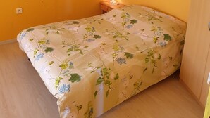A room with a bed, a nightstand with a lamp, and a wooden door. - Country house - Ideal for a team of workers (Nérac)