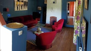Una sala de estar con un sofá rojo, una mesa de centro y una chimenea.
