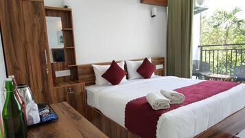 Habitación de hotel con una cama de madera, una mesita de noche, un espejo, un equipo de aire acondicionado y un balcón con mobiliario exterior.