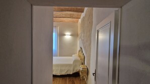 A narrow hallway leading to a bedroom with a bed, a nightstand, and a door. - Casa Siena Bruna, typical central apartment with breathtaking views (Siena)