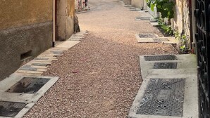 Une ruelle pavée bordée de bâtiments historiques dont les portes et les fenêtres sont bien visibles.