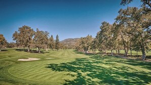 A golf course with a well-manicured fairway, sand bunkers, and a backdrop of trees and hills. - Napa Escape Luxe King Bed Near Wineries & Spa (Napa)