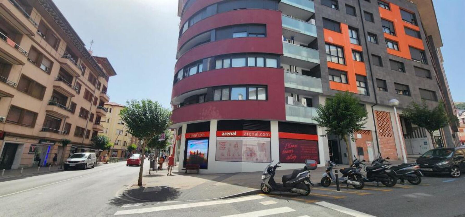 Un immeuble à plusieurs étages doté d’une façade incurvée, d’une entrée bien visible et d’une enseigne avec du texte.