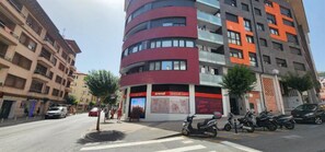 A multi-story building with a curved facade, a visible entrance, and a signboard with text. - Castro Apartment (Castro-Urdiales)