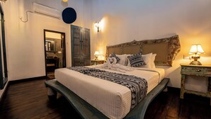 A bedroom with a large bed, bedside lamps, a wooden headboard, and a small table. - Beautiful villa with pool in charming Galle (Galle)